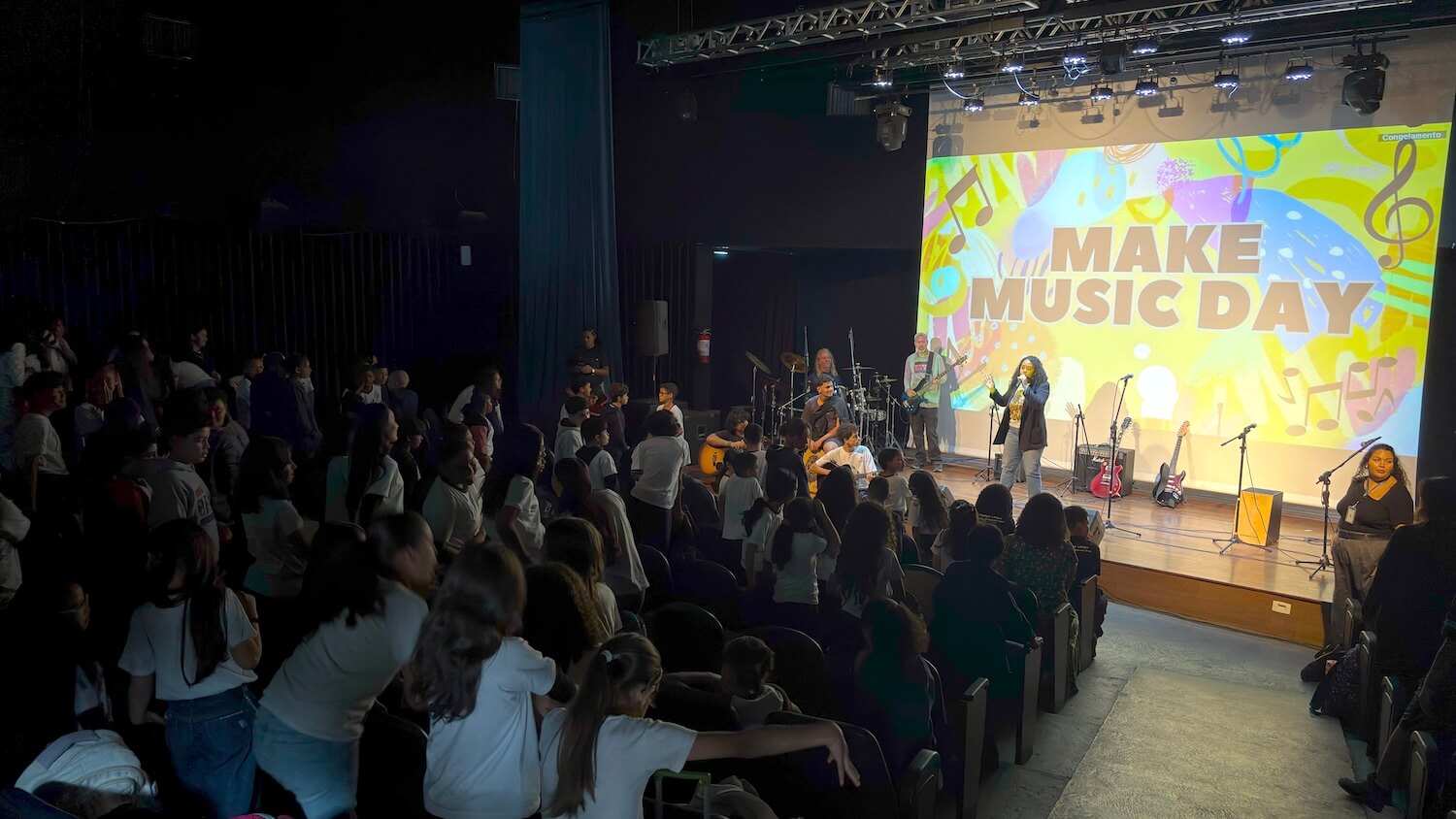 Auditório lotado de estudantes assistindo apresentação do Dia de Fazer Música | Make Music em São Paulo
