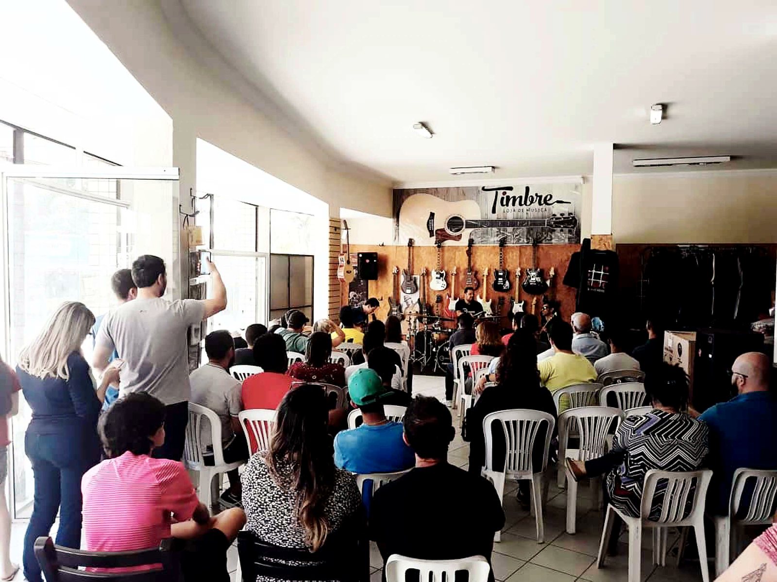 Apresentação musical dentro da Timbre Loja de Música com público sentado